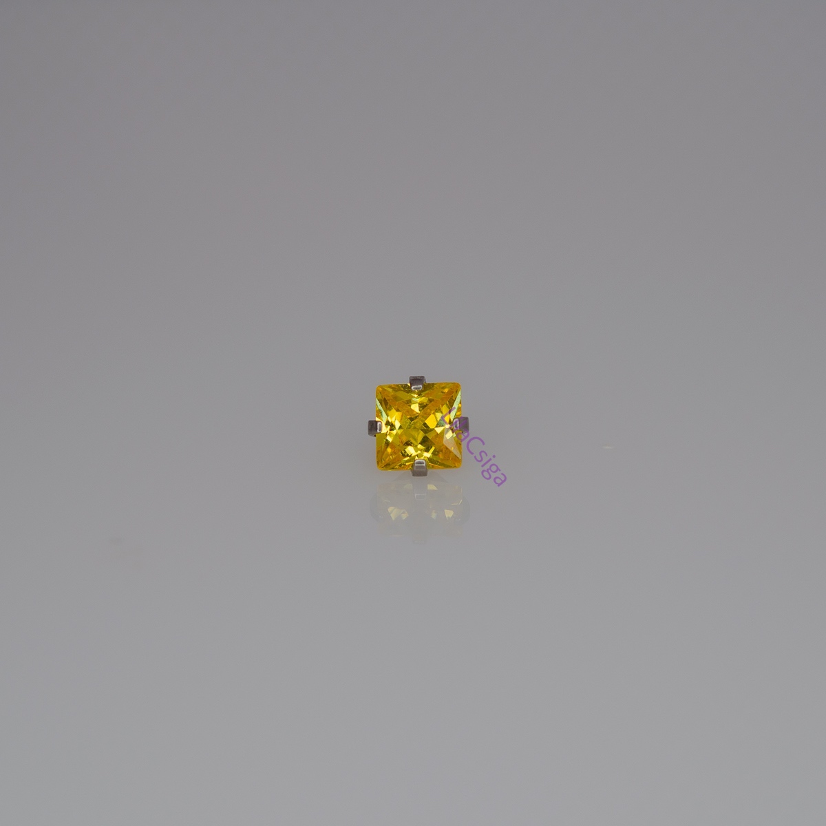Sárga négyzet alakú cirkónia kő ezüst színű foglalatban, fehér háttéren – menetes testékszer fej